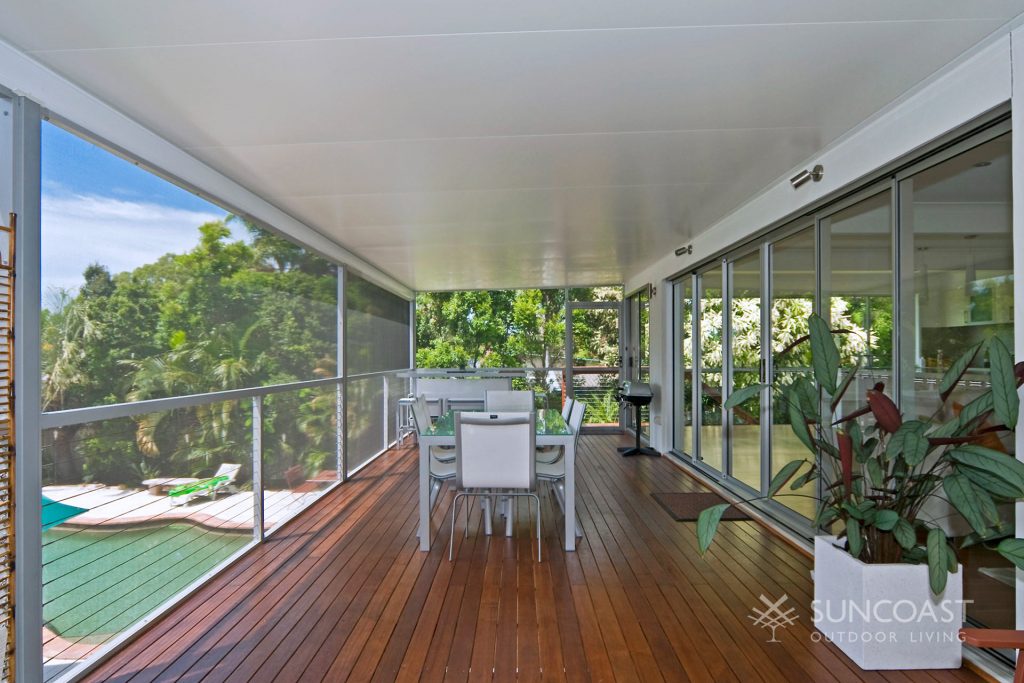 Enclosed deck and patio area with pool in background